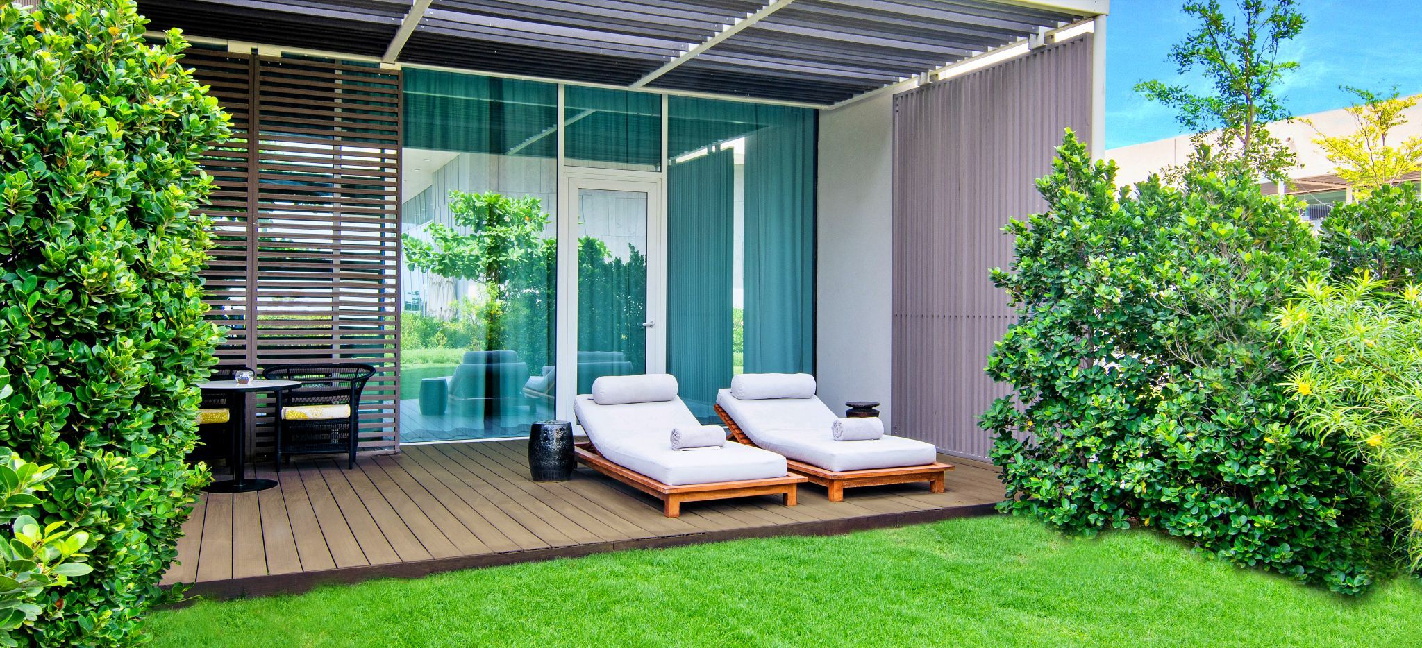 Eine Gartenterrasse mit zwei Strandliegen