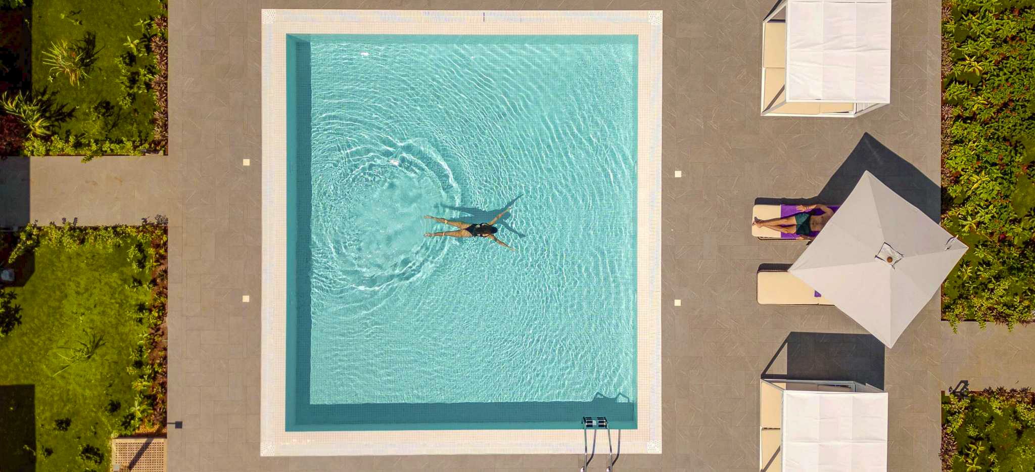 Eine Frau schwimmt in einem kleinen Pool im Hotel The Mora Zanzibar