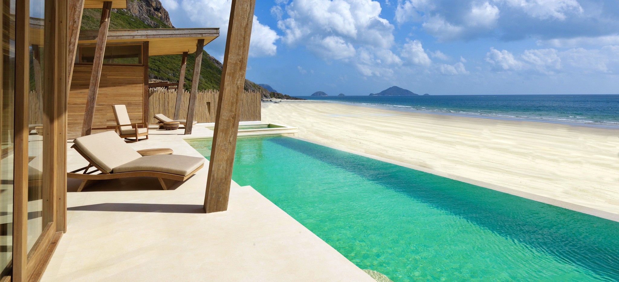 Die Terrasse einer Villa mit einem langem privaten Pool direkt am Strand