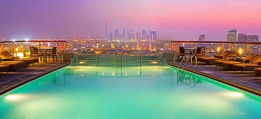Pool des Hotels "Hilton Dubai Creek" auf die Skyline Dubais. Hell erleichtet