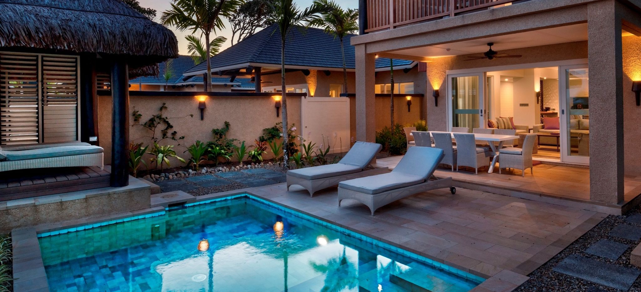 Außenbereich einer Beachfront Villa des Nanuku Resorts mit Essbereich, Liegen und Pool