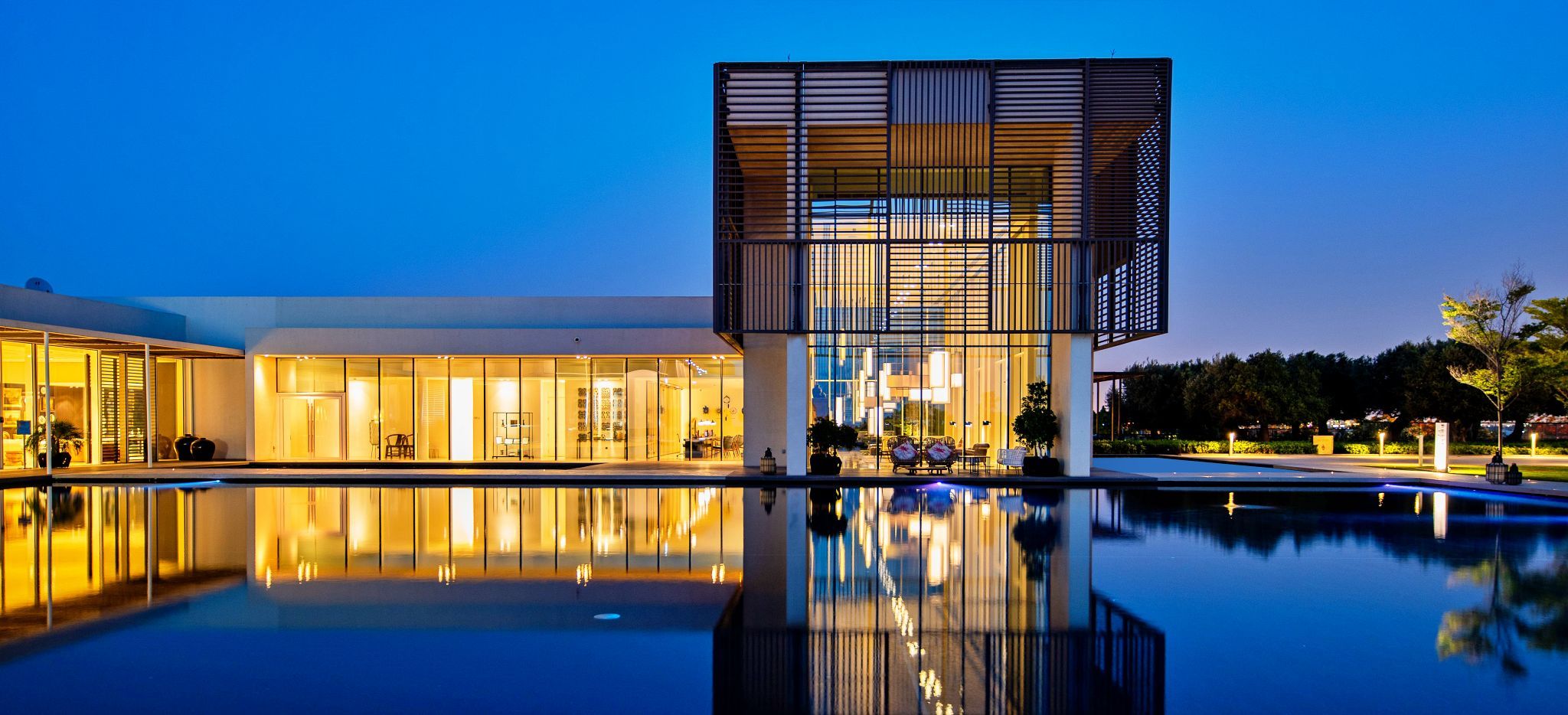 Ein großes, beleuchtetes Gebäude in der Nacht, im Hotel Oberoi Al Zorah, Ajman