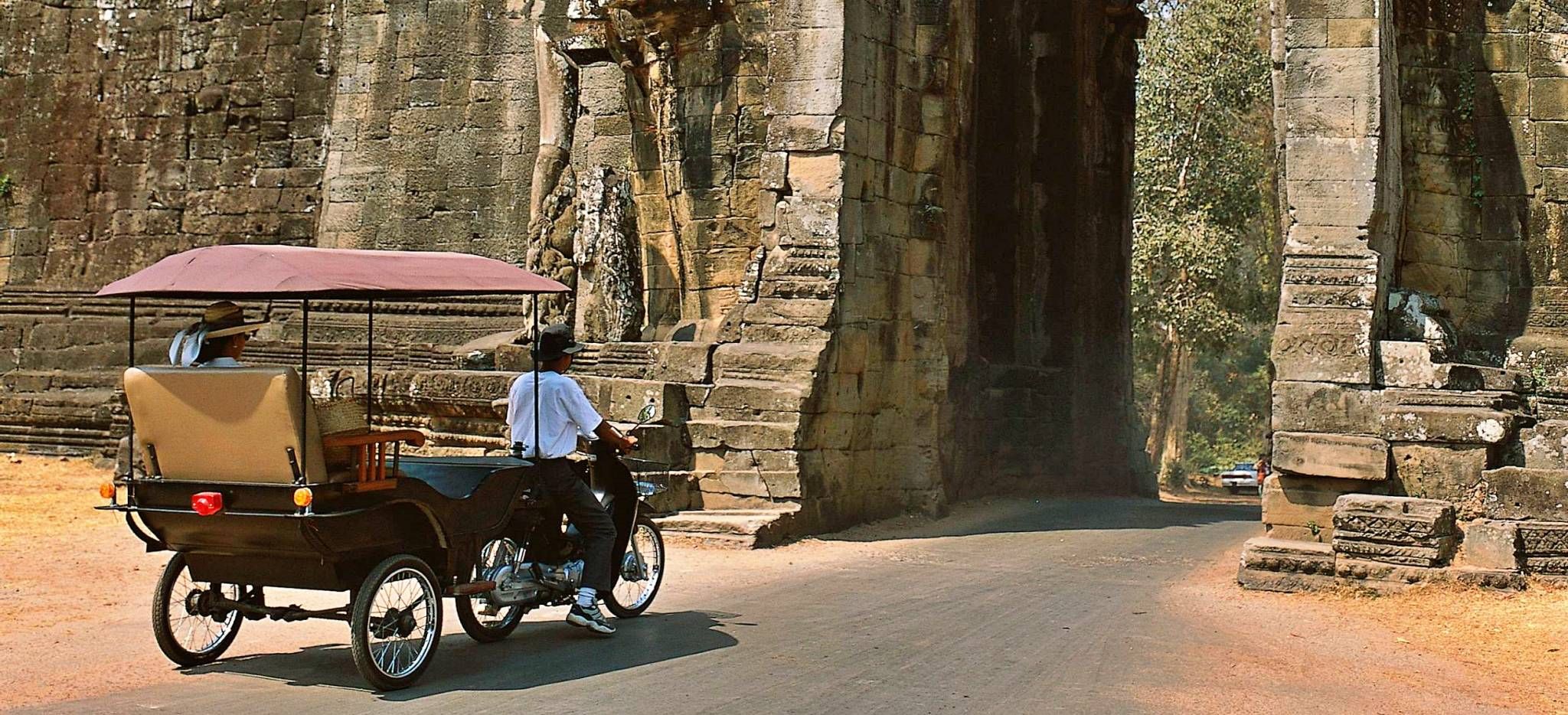 Tuk-Tuk mit Touristen an einem Eingang des Angkor Wat