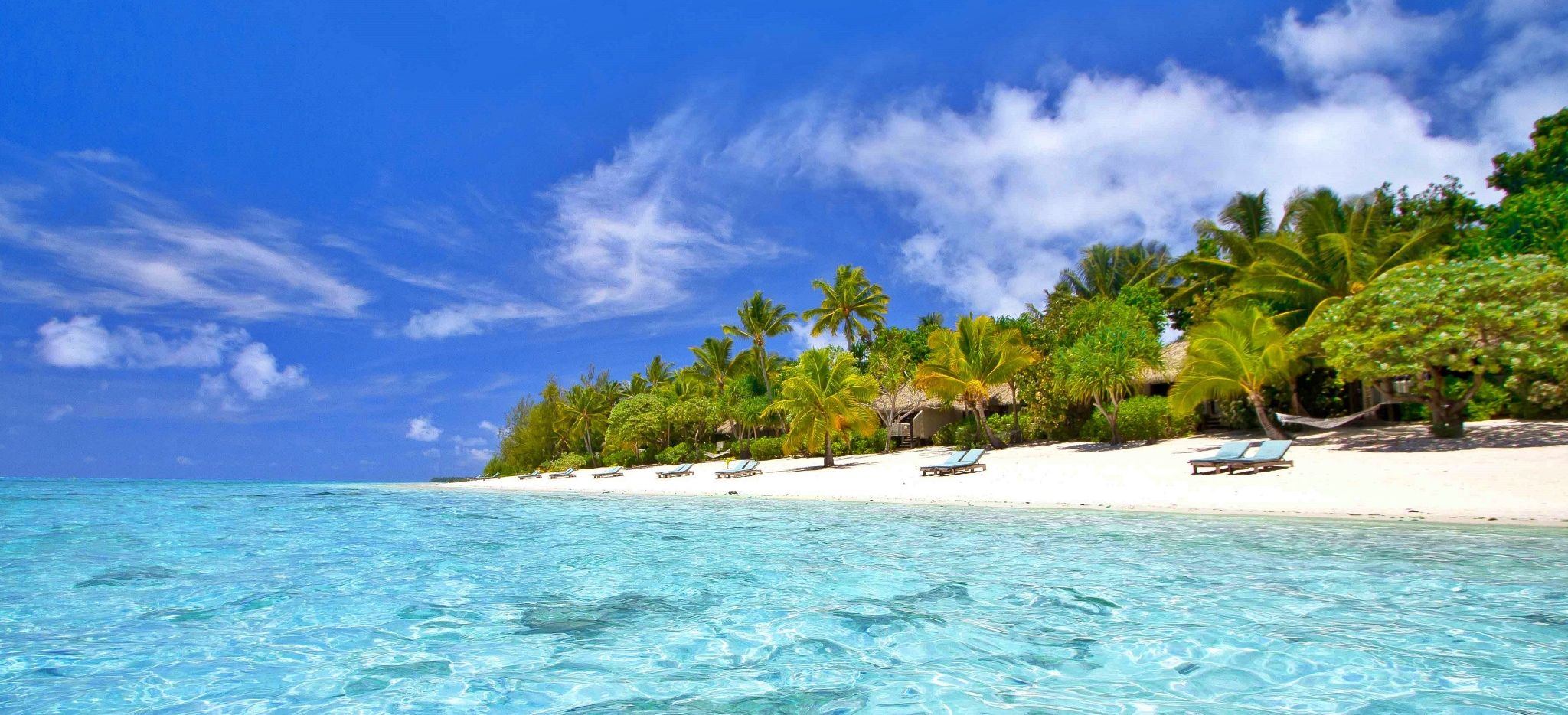 Blue Lagoon vor dem Pacific Resort Aitutaki mit Blick auf den Strand und die Palmen 