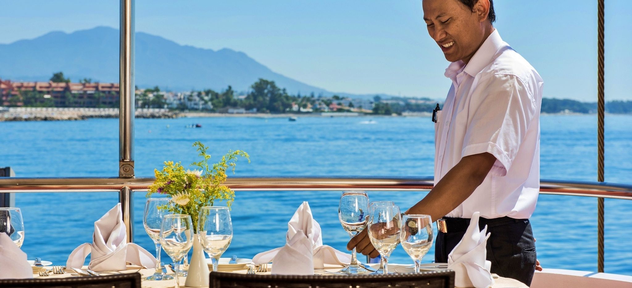 Essbereich draußen der Variety Cruises Südsee mit einem Kellner auf dem Foto