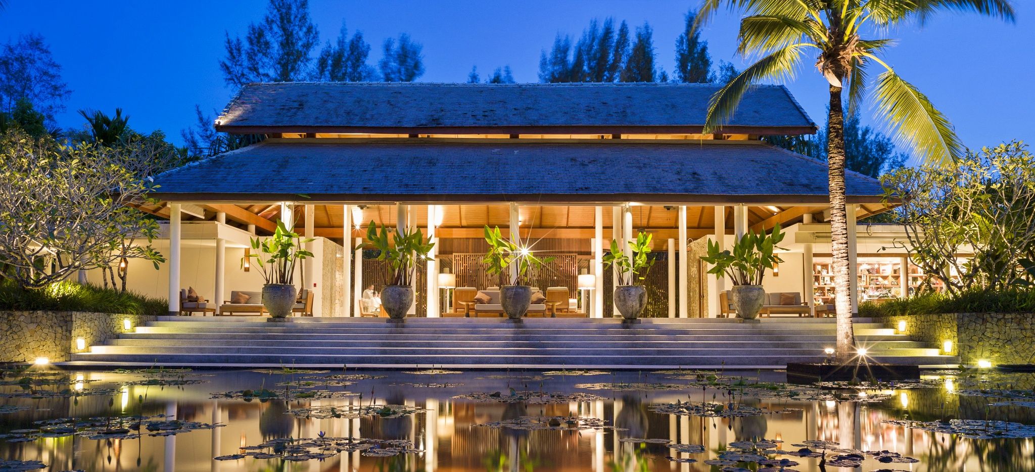 Die Hotellobby des "The Sarojin" in Thailand hinter einem kleinen See