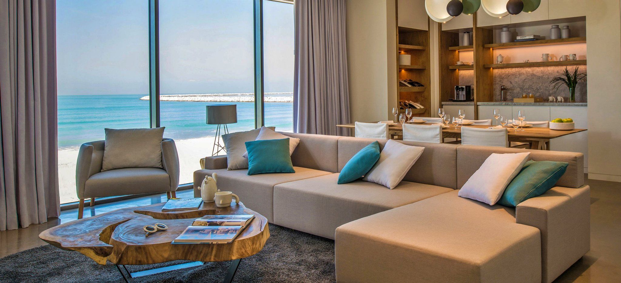 Ein Wohnzimmer mit einer großen Couch und Blick auf das Meer Dubais