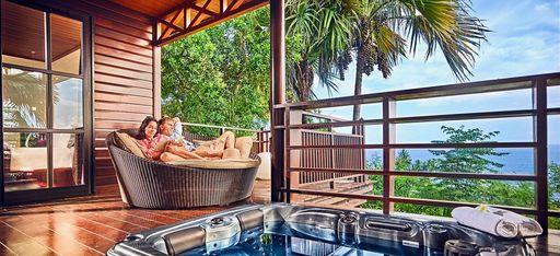 Ein Paar sitzt auf einer Terrasse mit Jacuzzi im Hotel Palm auf La Réunion