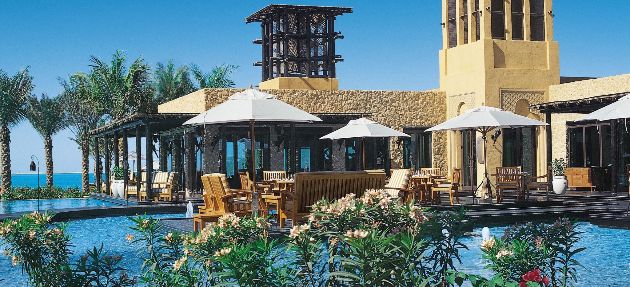 Pool mit Hauptrestaurant im Hotel "One&Only Royal Mirage", Palmen und Meer im Hintergrund