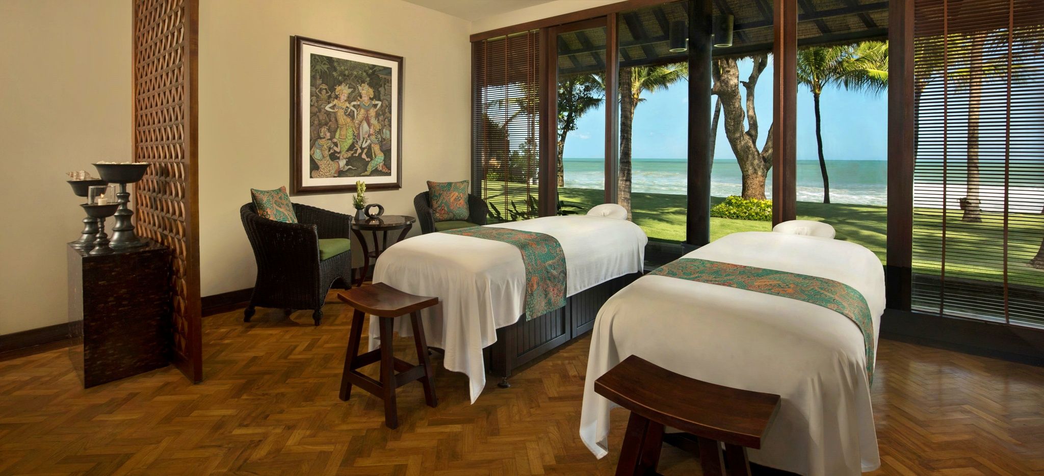 Zwei Massageliegen mit Blick auf den Strand in einem großen Raum, im Hotel "The Legian" auf Bali