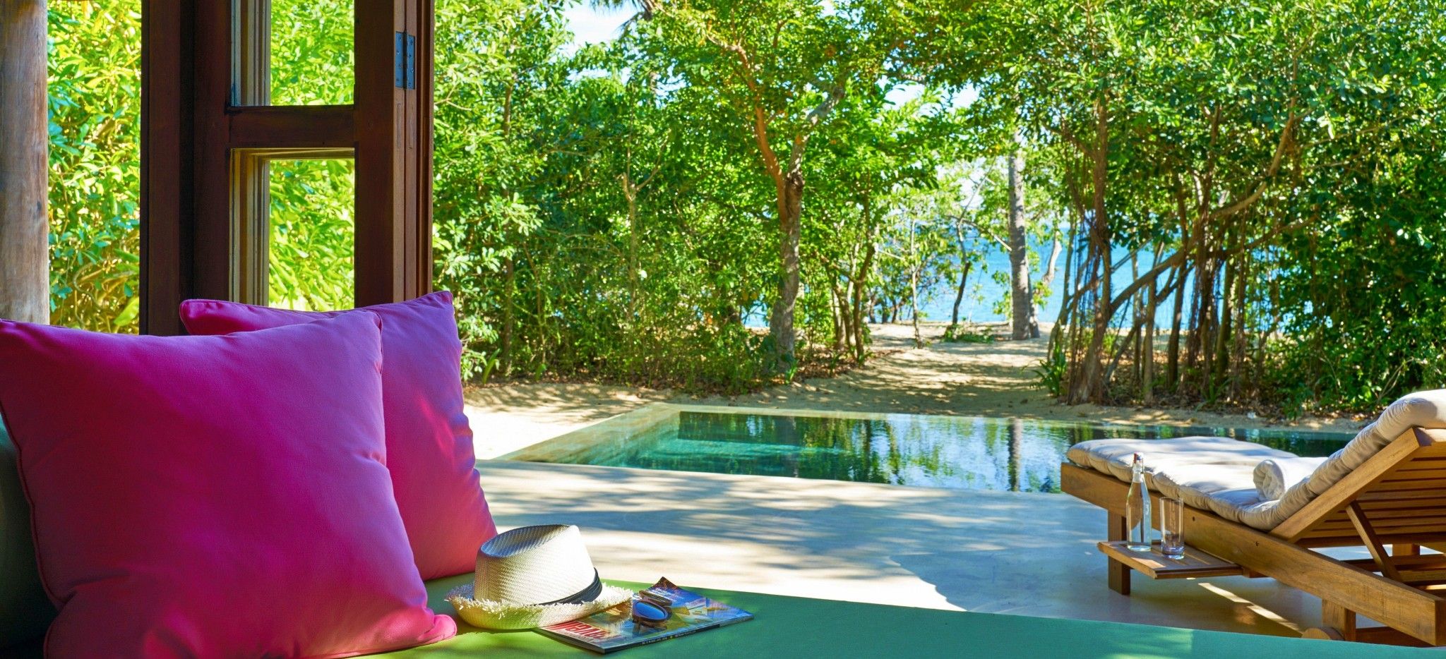 Eine Terrasse mit einem Privatem Pool und einem Zugang zum Strand