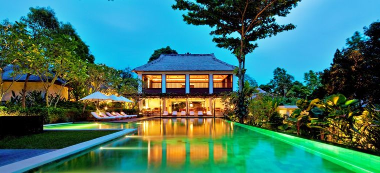 Ein beleuchteter Pavillion am Ende eines langen Pools im Hotel "COMO Uma Ubud" in Bali