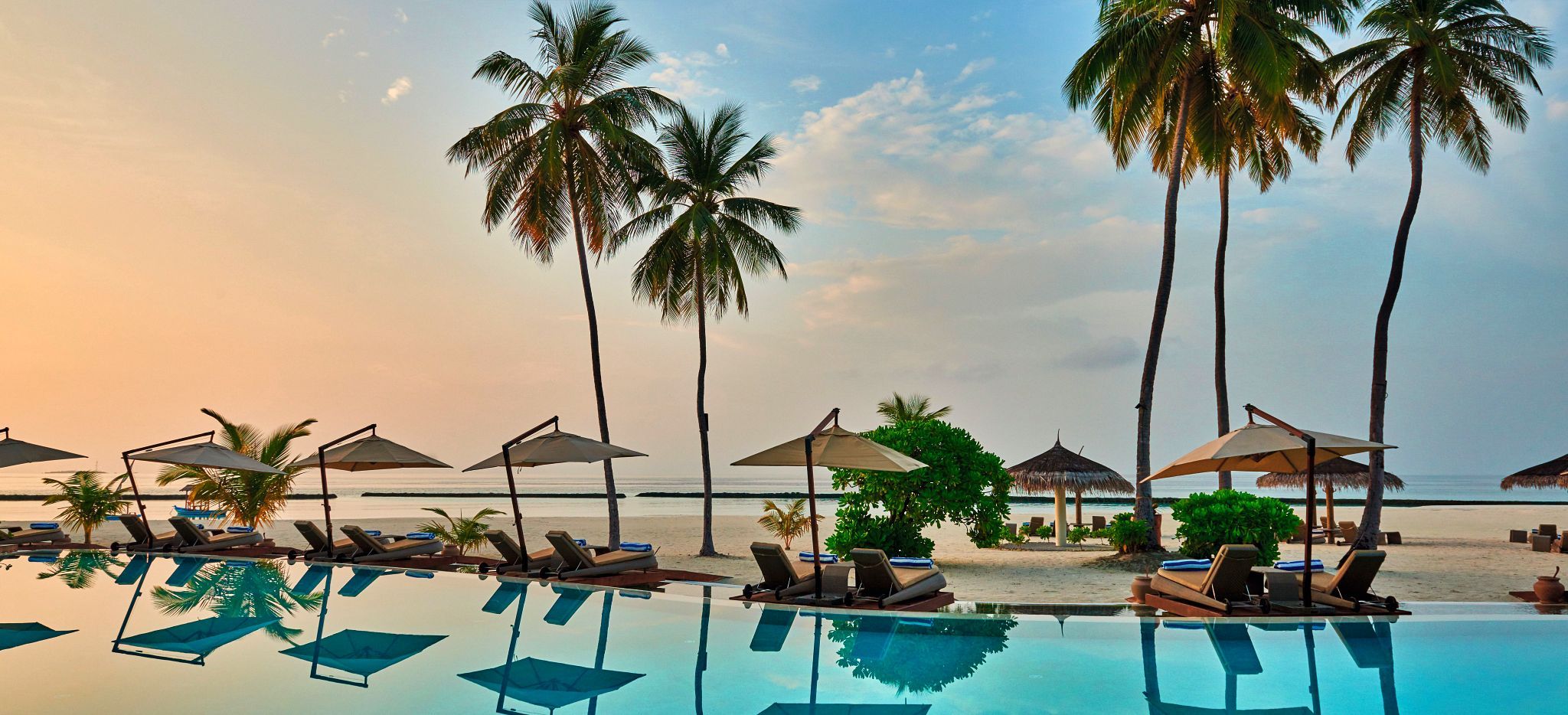 Ein Pool mit Blick auf den Strand und das Meer einer Malediveninsel