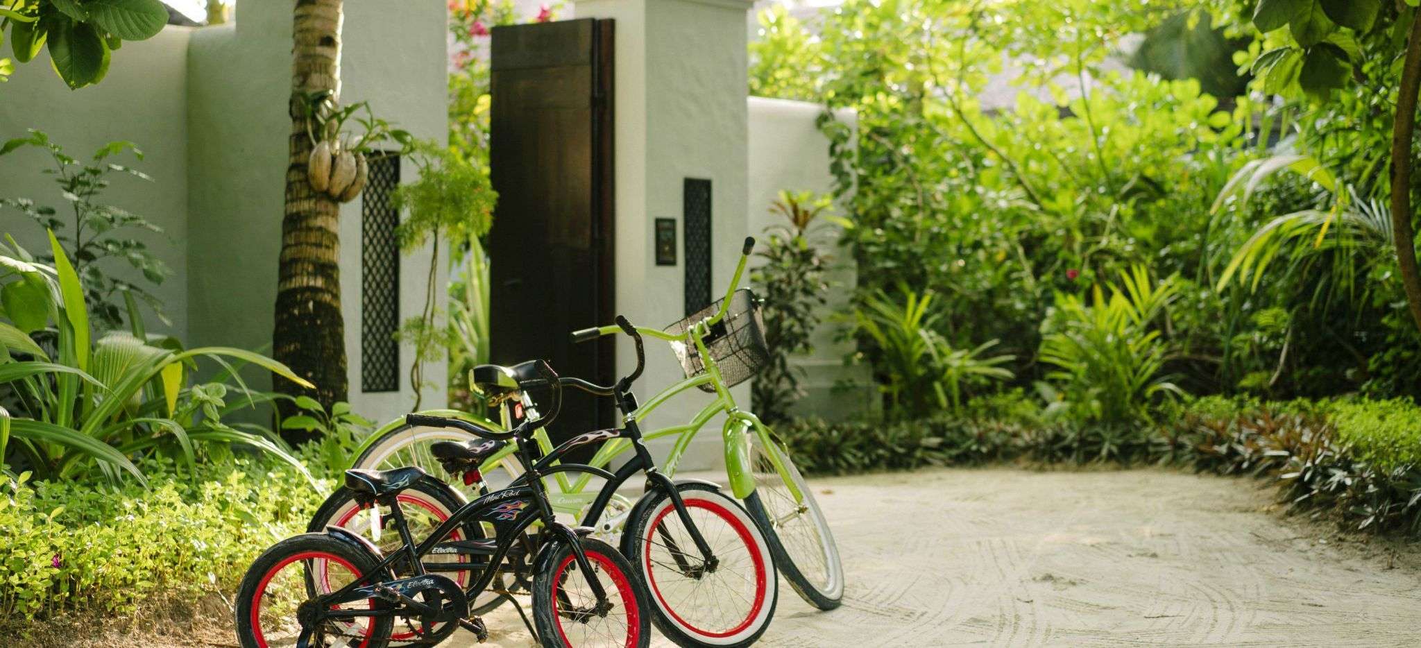 Vier Fahrrader vor dem Eingang einer Beach Residence im Anantara Kihava