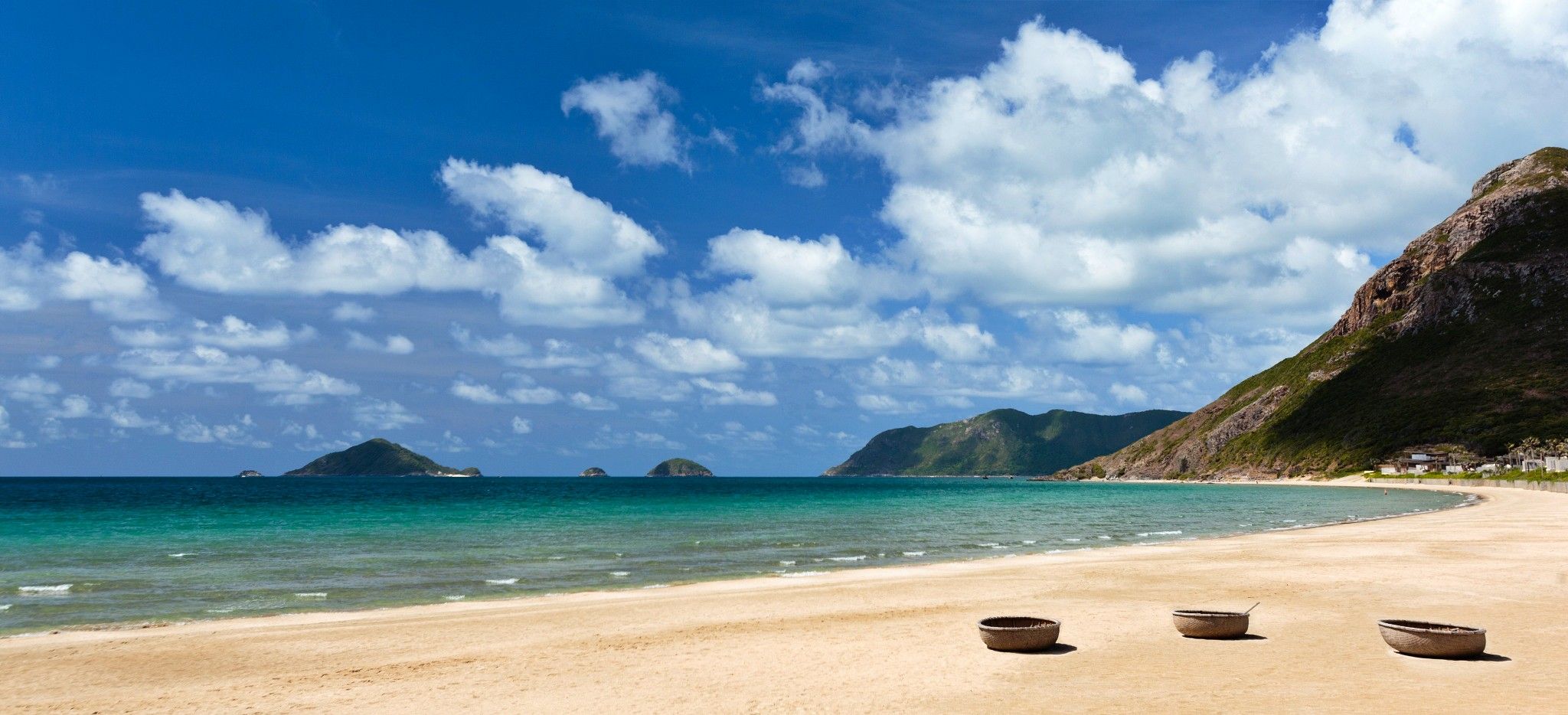 Ein langer Strand in Vietnam, mit Blick auf vorliegende Inseln im Meer