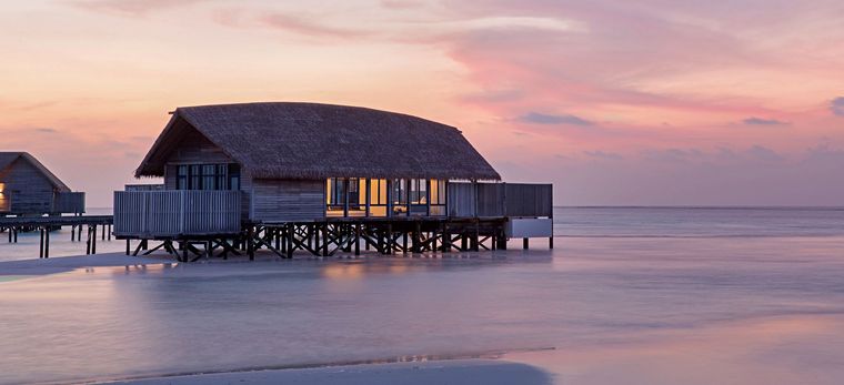 Wasservilla im Hotel COMO Cocoa Island, Malediven, bei Sonnenuntergang