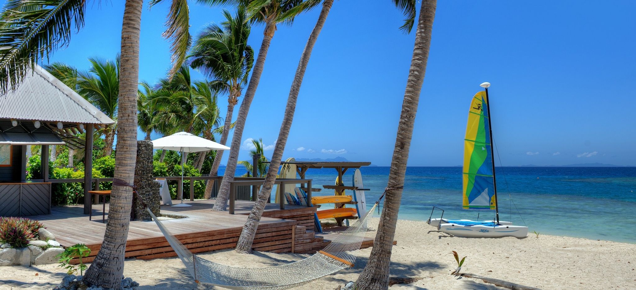 Segelboot, Surfbretter und Kanus am Strand vom Hotel Vomo Island Fiji