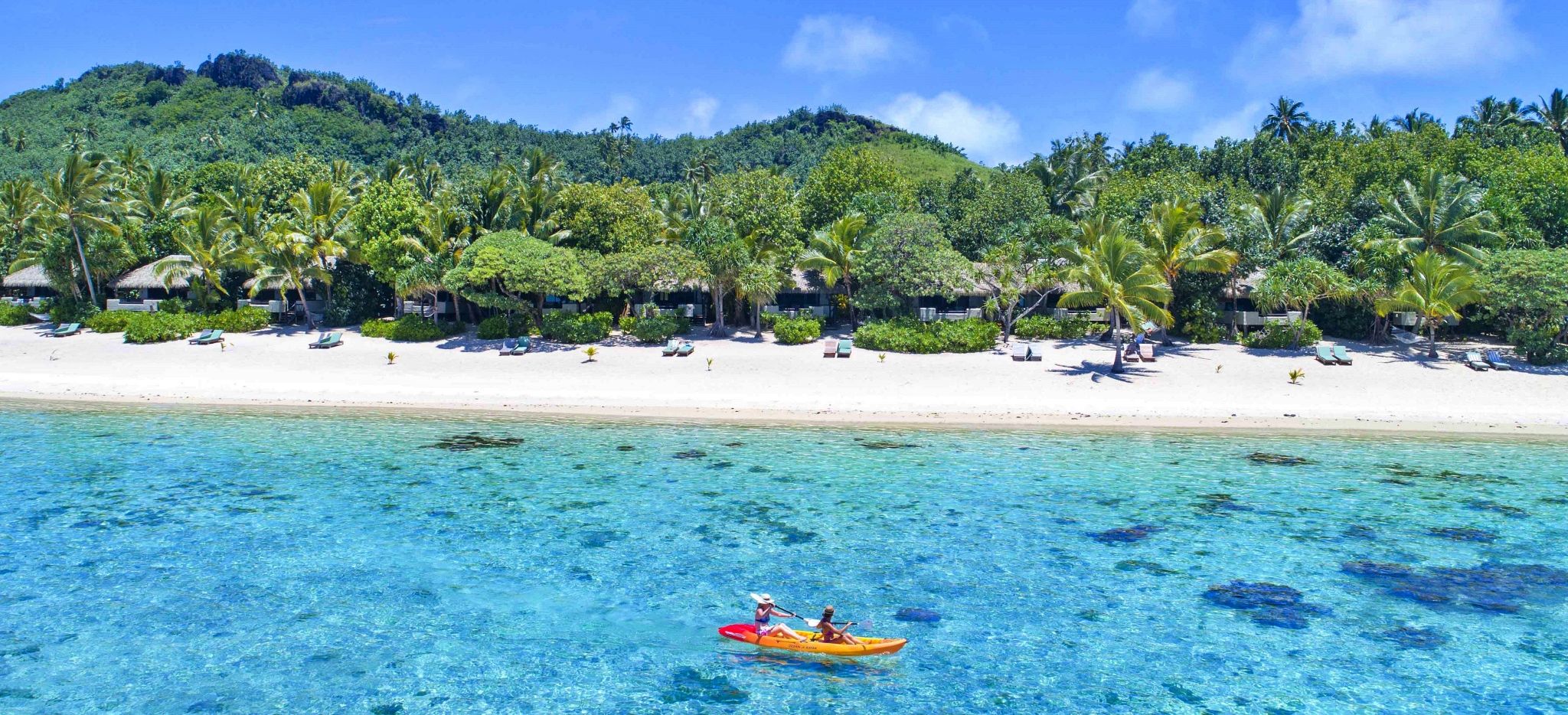 Kajakfahren im Meer mit dem Pacific Resort Aitutaki im Hintergrund