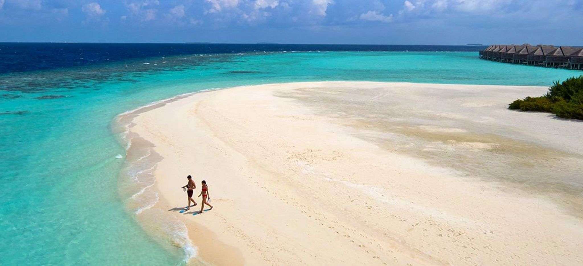 Ein paar spaziert am weißen Sandstrand auf den Malediven