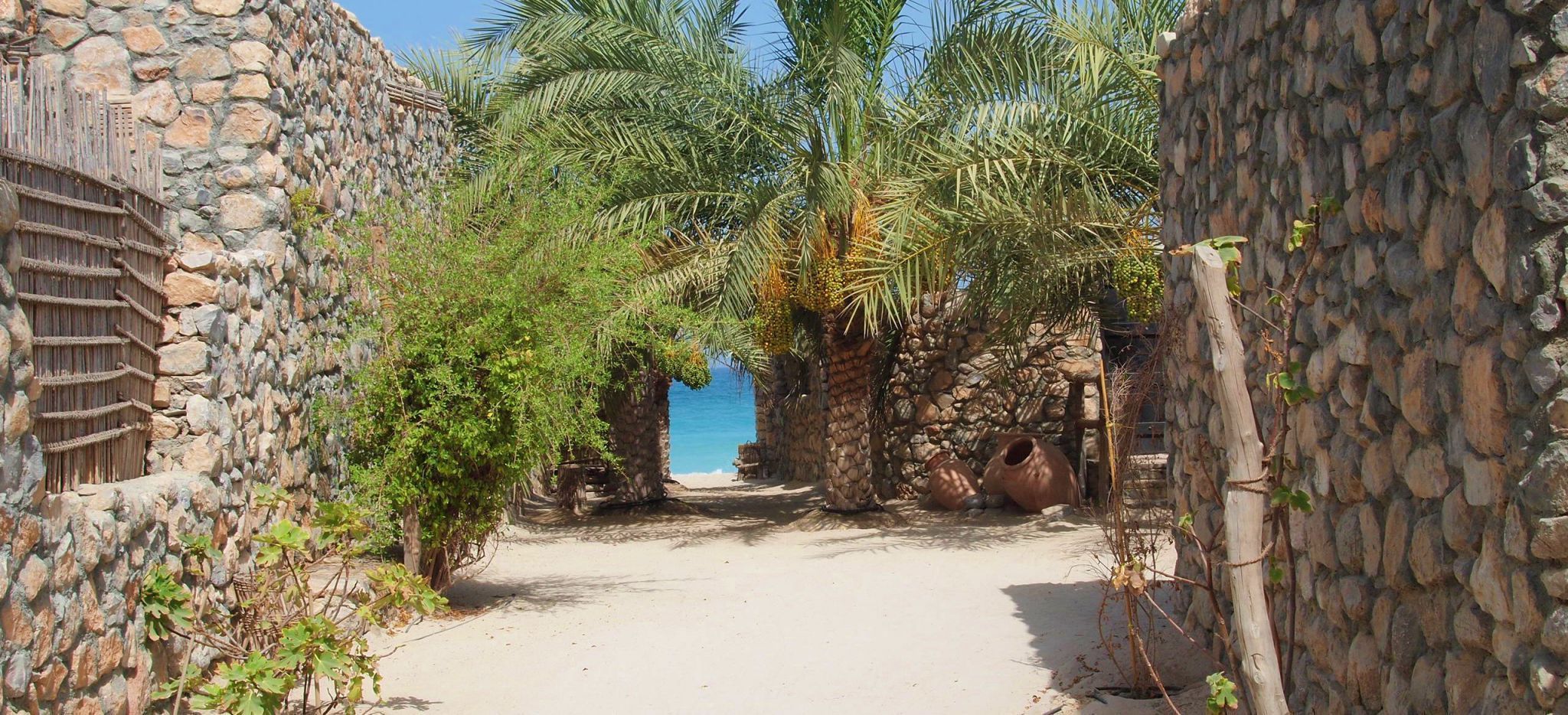 Weg zwischen steinernen Häusern am Strand im Hotel "Six Senses Zighy Bay" im Oman