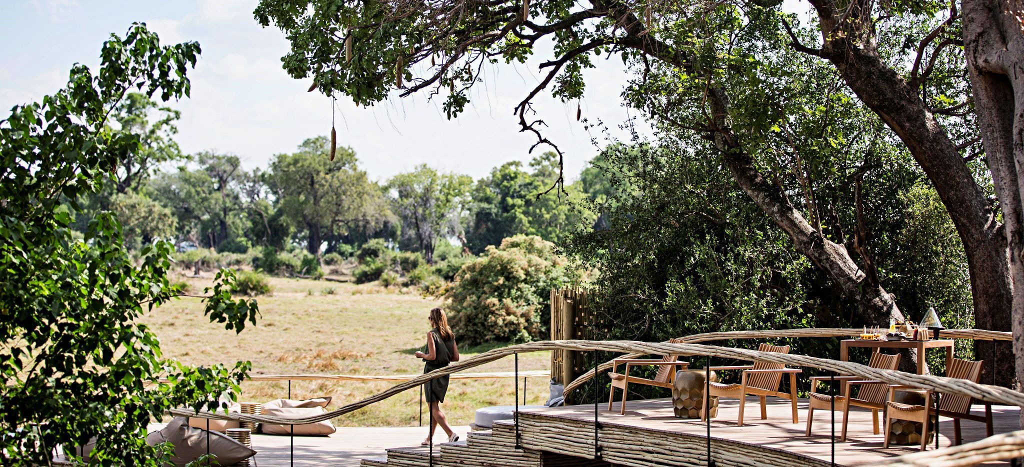 Eine Frau auf der Terrasse eines der Zimmer der Safari-Lodge "Little Mombo" in Botsuana