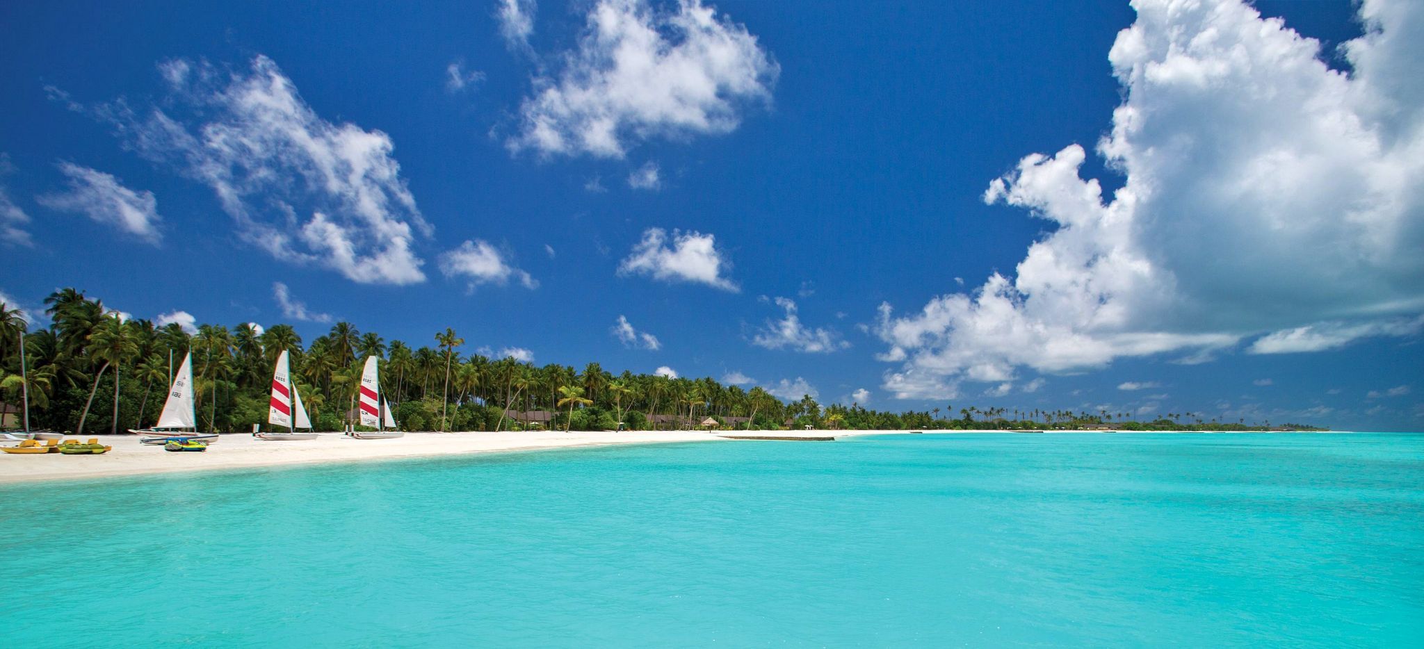 Mehrere Segelboote aufgereit auf einem Strand auf den Malediven. Das Hotel Atmosphere Kanifushi