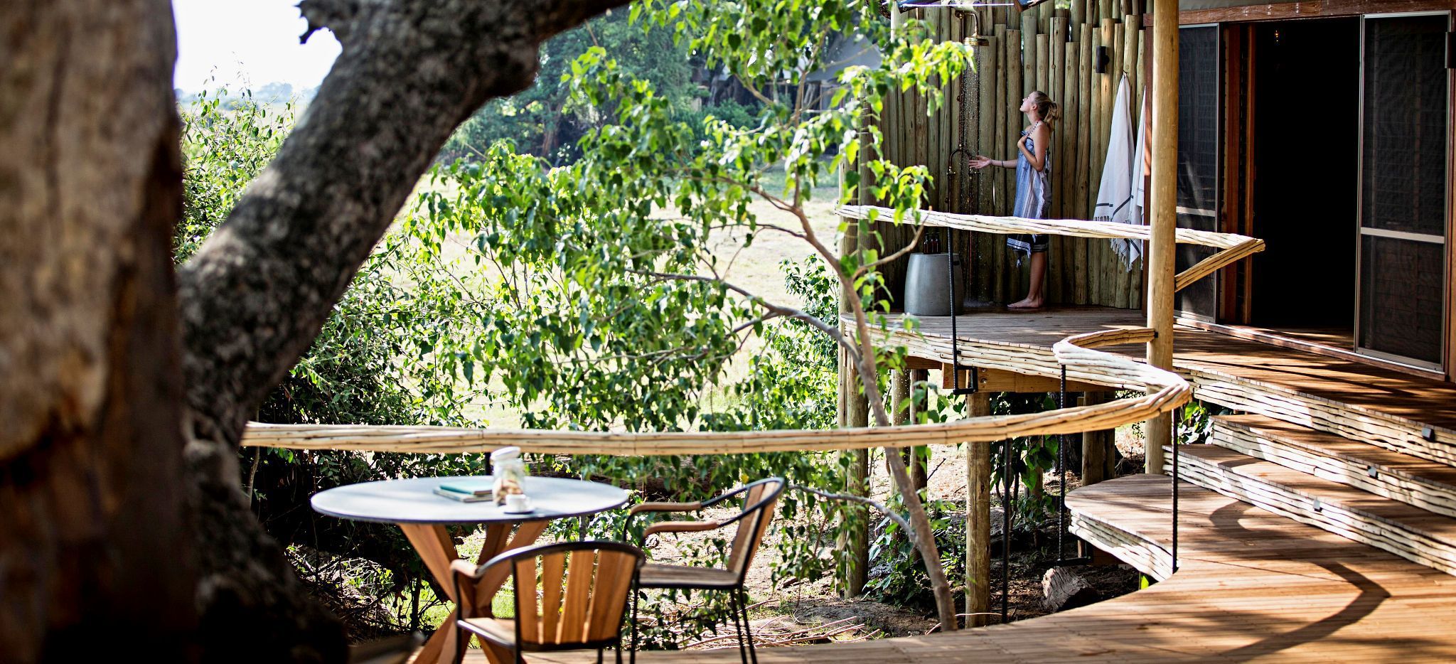 Eine Frau duscht auf der Terrasse ihres Hotelzimmers in der Safari-Lodge "Little Mombo" in Botsuana