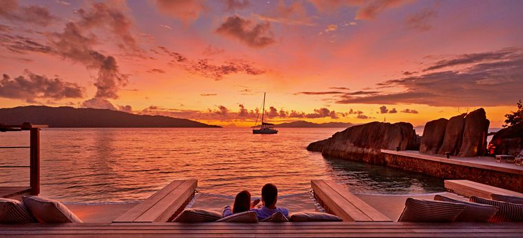 Ein Paar betrachtet den Sonnenuntergang im Hotel Six Senses Zil Pasyon auf den Seychellen