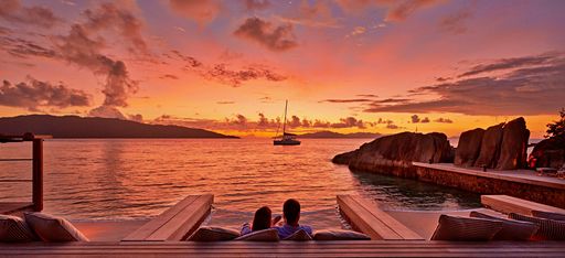 Ein Paar betrachtet den Sonnenuntergang im Hotel Six Senses Zil Pasyon auf den Seychellen